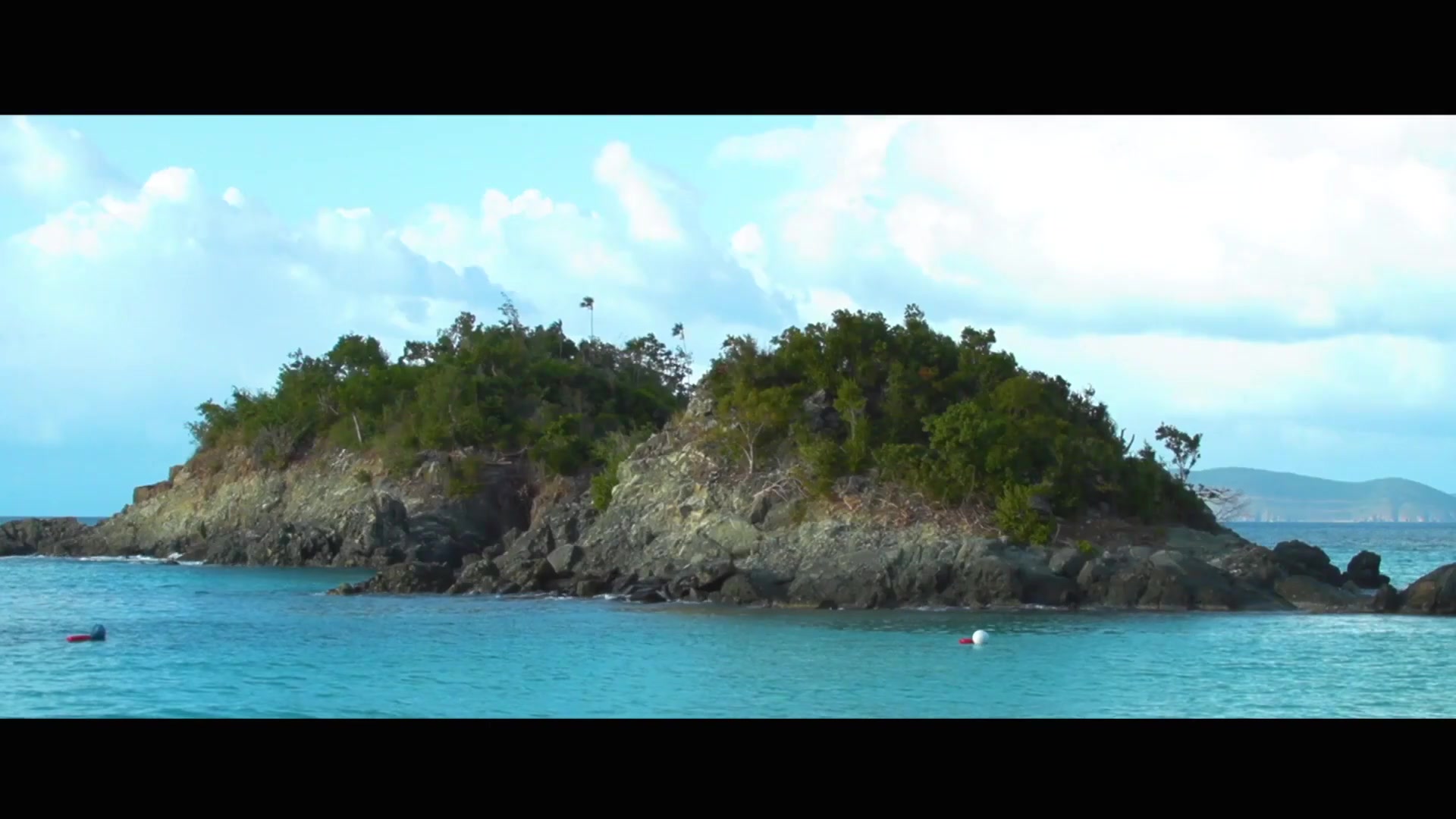 A rocky island rises from Caribbean turquoise water — U.S. Virgin Islands, Real Nice campaign